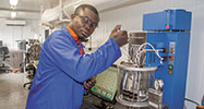 WearCheck's Daniel Boakye calibrates a viscometer bath in the West African laboratory.